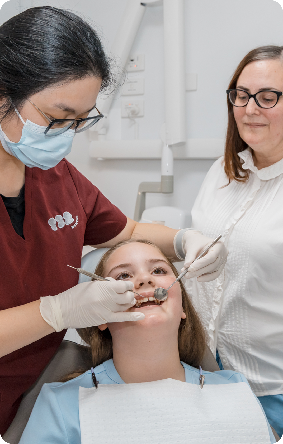 Principal Dentist Dr. Nadia providing comprehensive dental services by examining a child's teeth in T32 Dental.