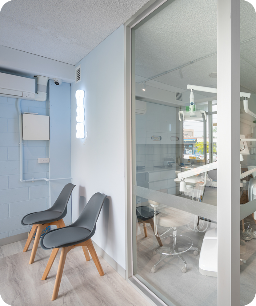 T32 Dental clinic room with modern chairs, glass partition, and bright lighting.