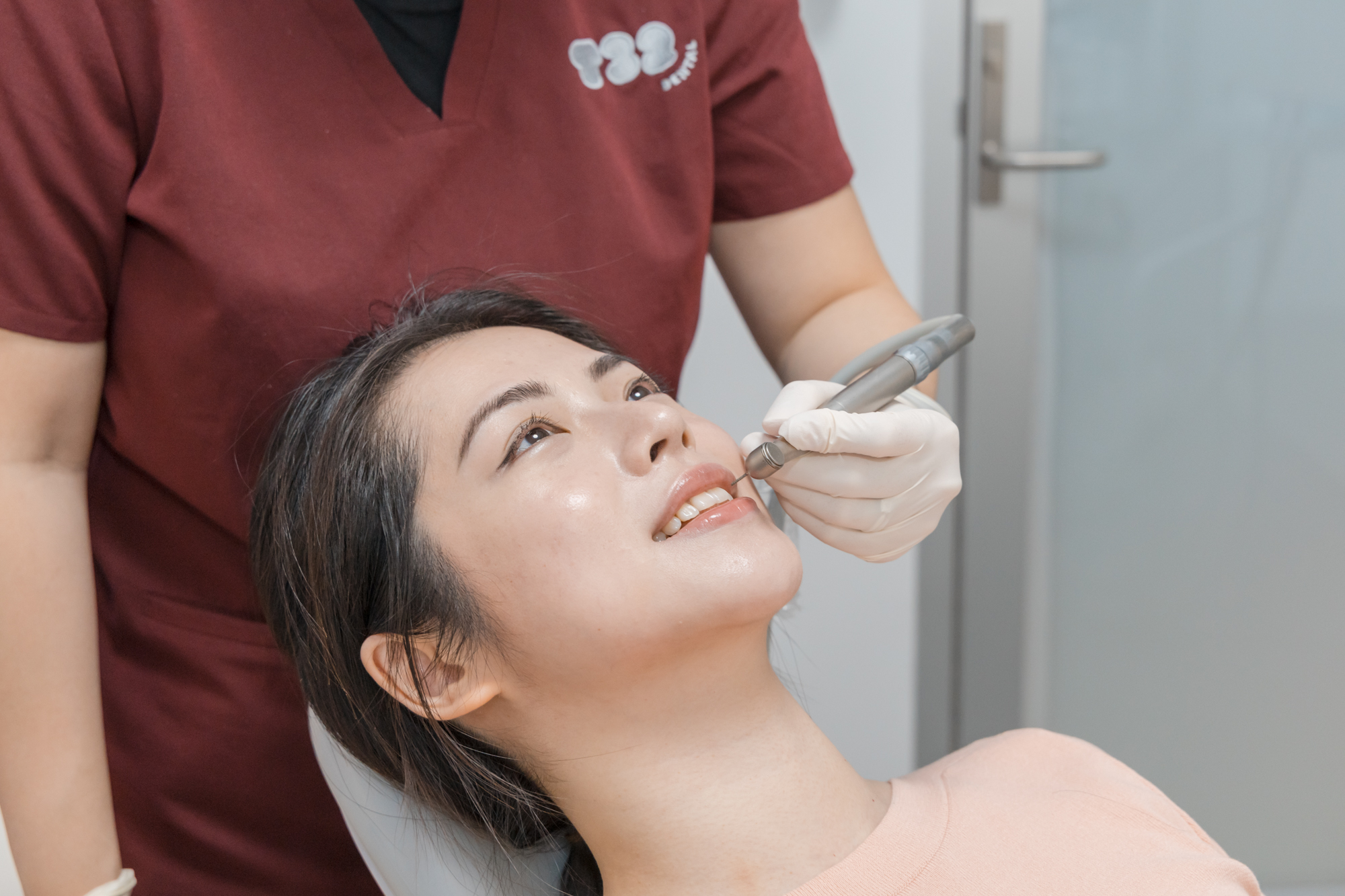 Dentist preparing a patient's front teeth for a porcelain veneer procedure in a clinic.