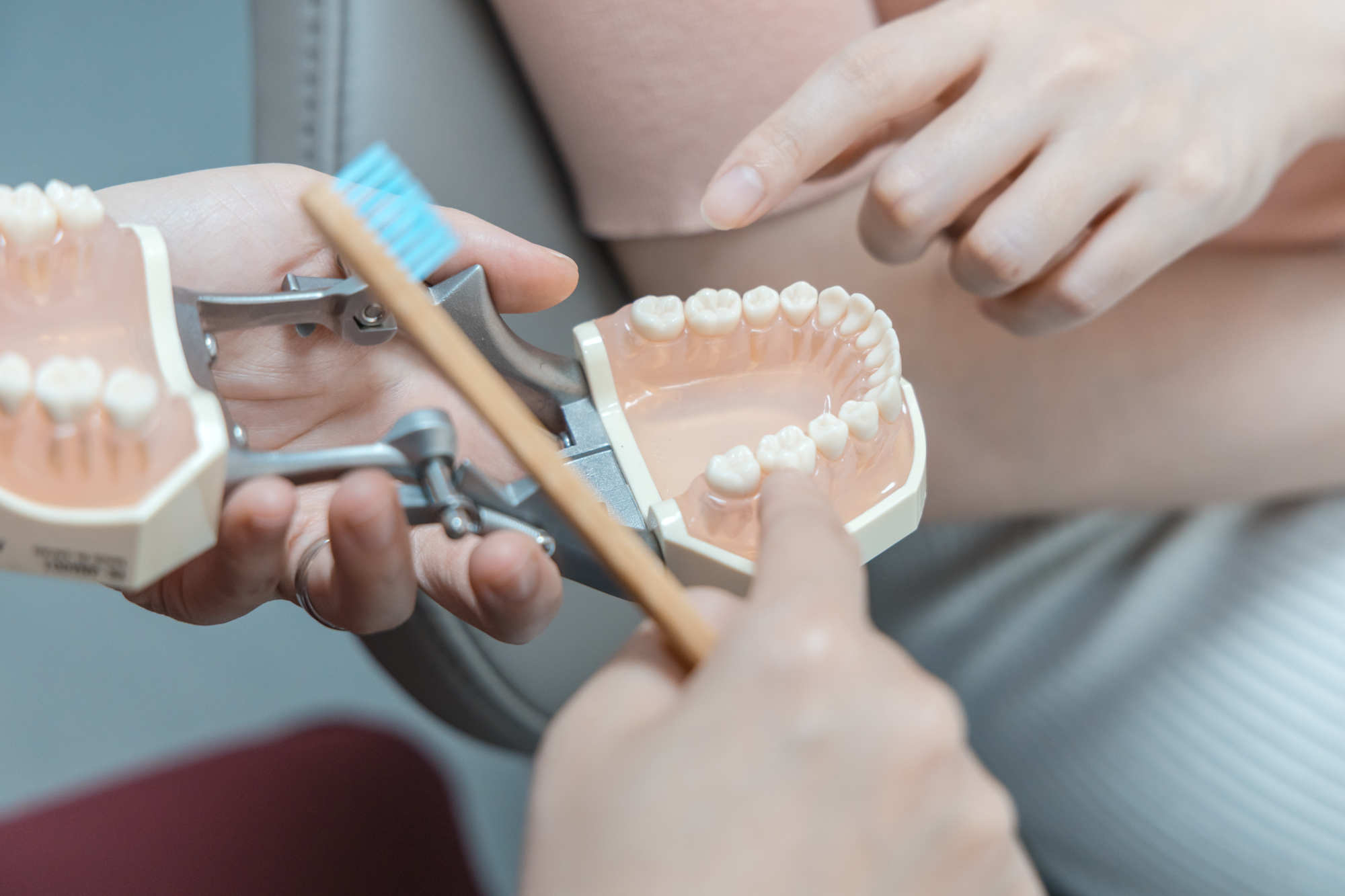 Dentist using a tooth model to explain the placement and fit of a porcelain veneer.