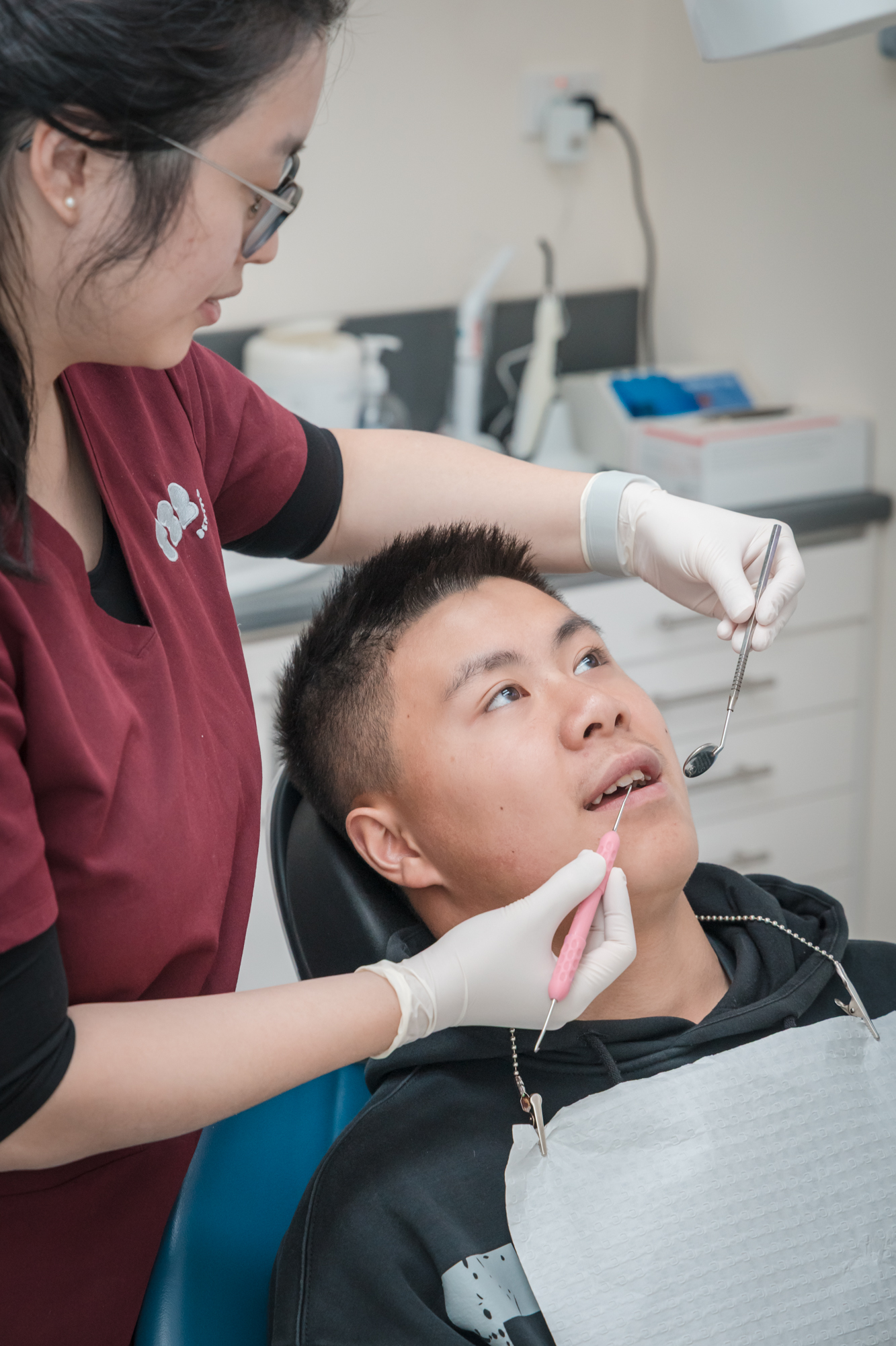 Dentist examining patient's teeth and overall oral health as part of a teeth whitening consultation.