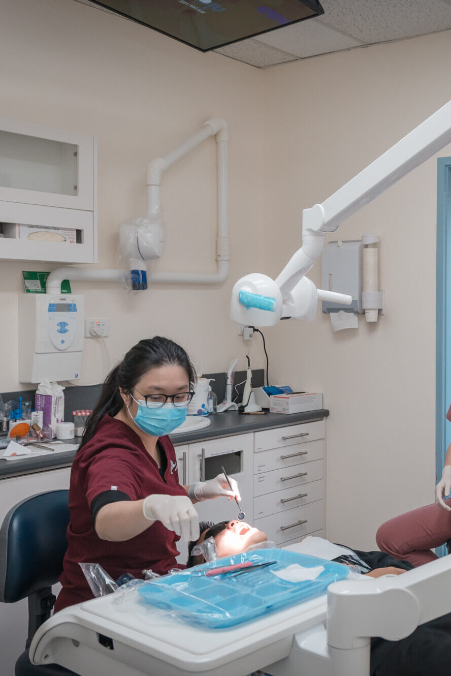 Dentist preparing a patient for a wisdom teeth removal procedure in a modern dental clinic.
