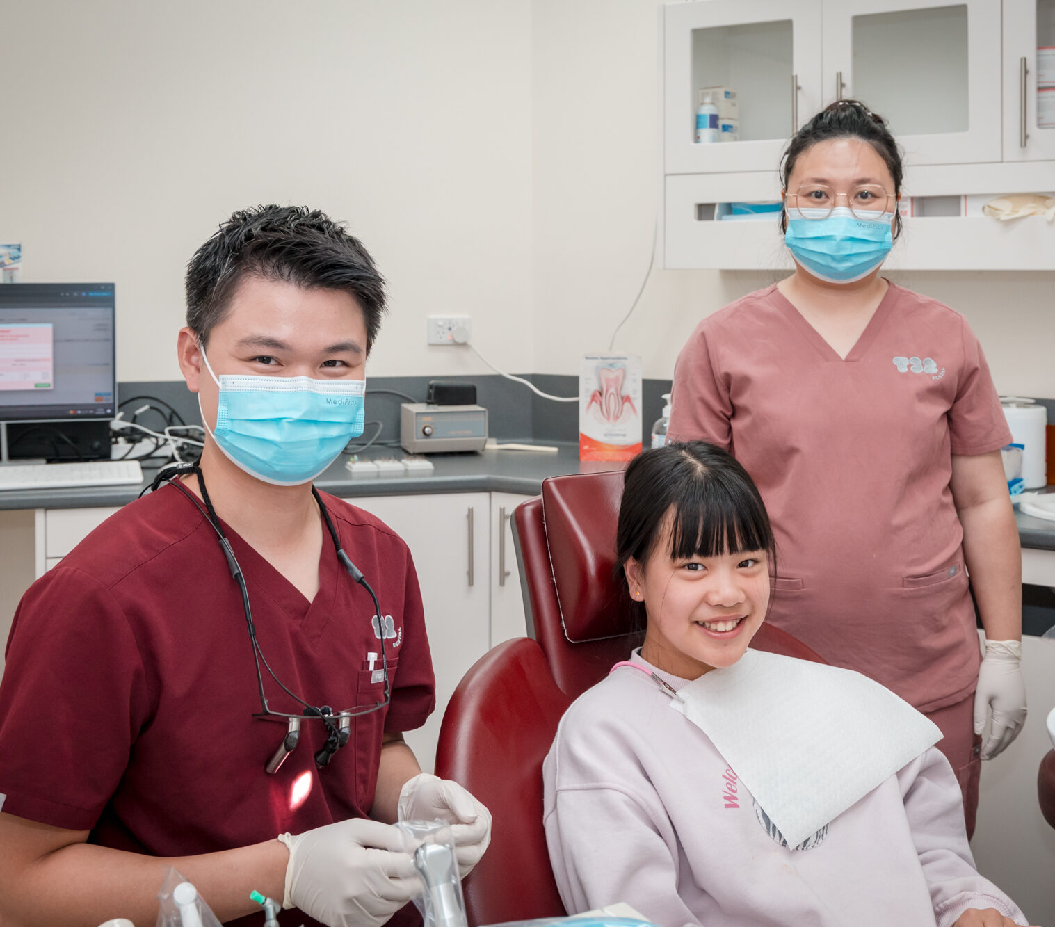 A patient smiles during a clinic consultation for dentures with her professional health care team.