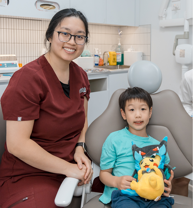 A friendly dentist prepares a relaxed young boy for a pediatric dental filling in a modern clinic.