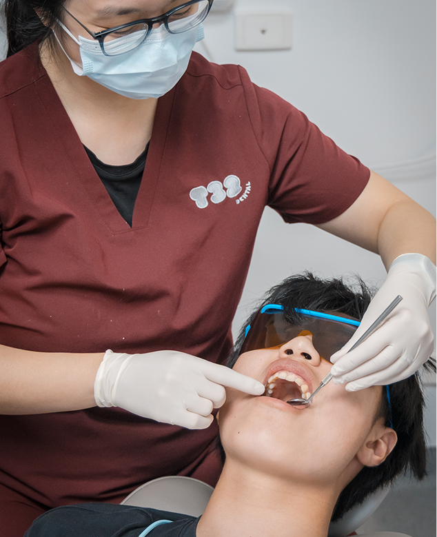 Close-up of a dentist assessing a patient's teeth as a candidate for composite veneers treatment at a dental clinic.