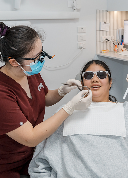 Dentist examining a patient's tooth to determine if they are a candidate for dental inlays and onlays.