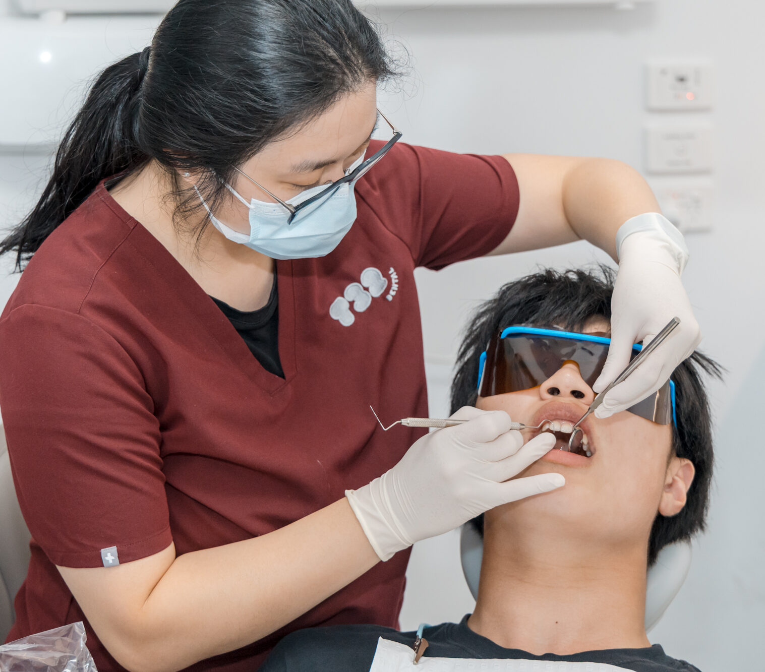A dentist evaluates a patient's deep tooth grooves before applying protective fissure sealants.