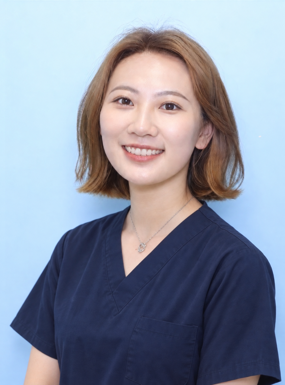 Smiling dentist in blue medical scrubs.