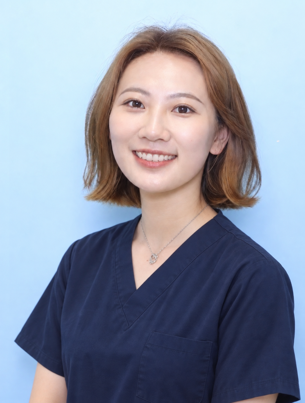 Smiling dentist in blue medical scrubs.